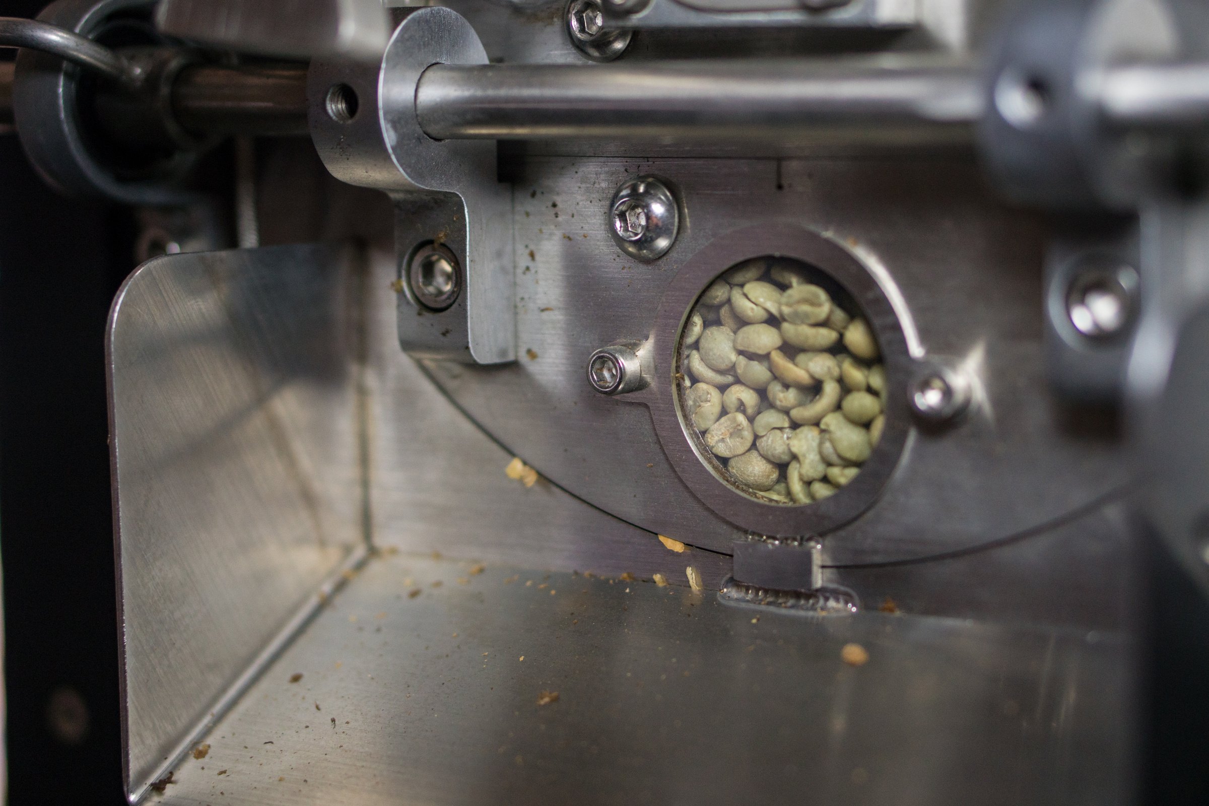 raw coffee beans roasting in a coffee roaster